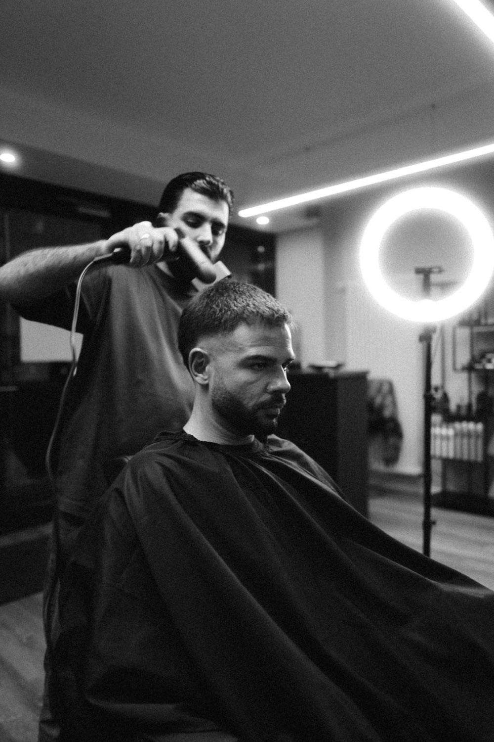 Barber schneidet einen kurzen Herrenschnitt mit der Maschine im Studio Haco Hamburg